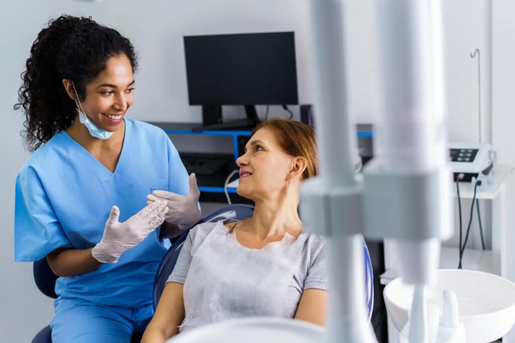 Dental professional discussing custom oral appliance therapy for sleep apnea with a patient.