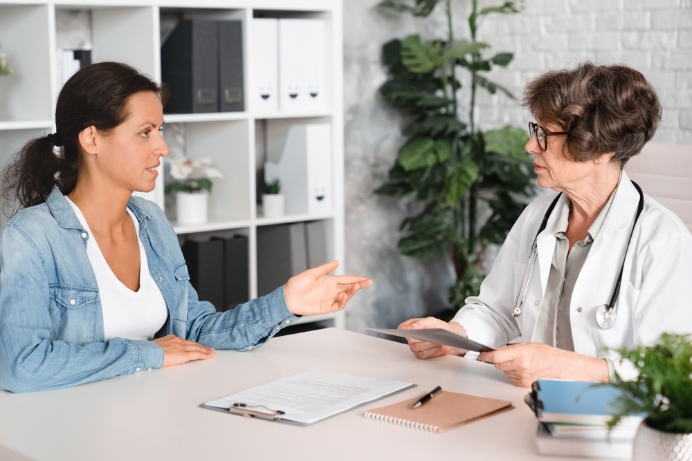 Dental professional reviewing a preventive care plan with a patient on a tablet.